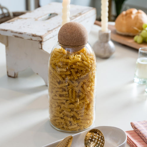 Acacia storage container filled with dried pasta on table kitchen storage